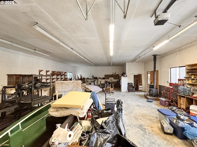 misc room with a wood stove and unfinished concrete floors