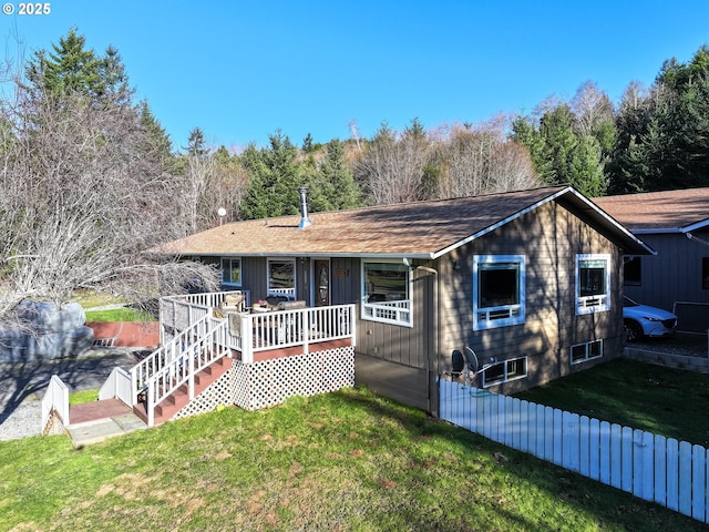 ranch-style home featuring a deck and a front lawn