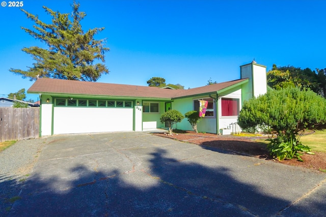 825 Seabreeze Ter, Coos Bay, OR 97420 - view of front of house featuring driveway, a garage, stucco siding, and a chimney