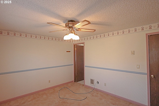 825 Seabreeze Ter, Coos Bay, OR 97420 - carpeted empty room featuring a wainscoted wall, a ceiling fan, wallpapered walls, and a textured ceiling