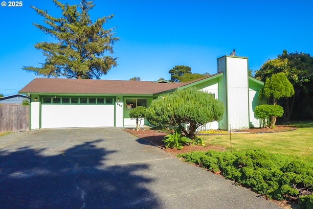 825 Seabreeze Ter, Coos Bay, OR 97420 - mid-century modern home with asphalt driveway, an attached garage, and a chimney