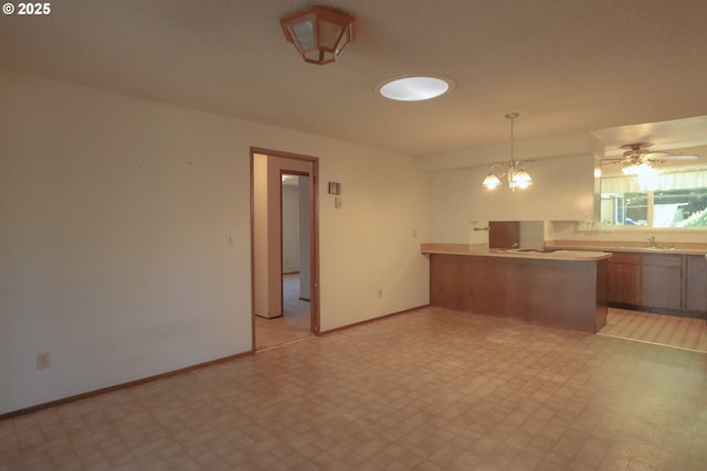 825 Seabreeze Ter, Coos Bay, OR 97420 - kitchen featuring a peninsula, light floors, light countertops, decorative light fixtures, and a chandelier