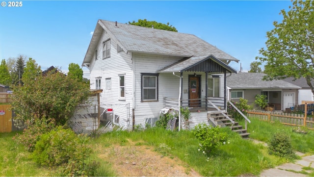 bungalow-style home with fence and a shingled roof