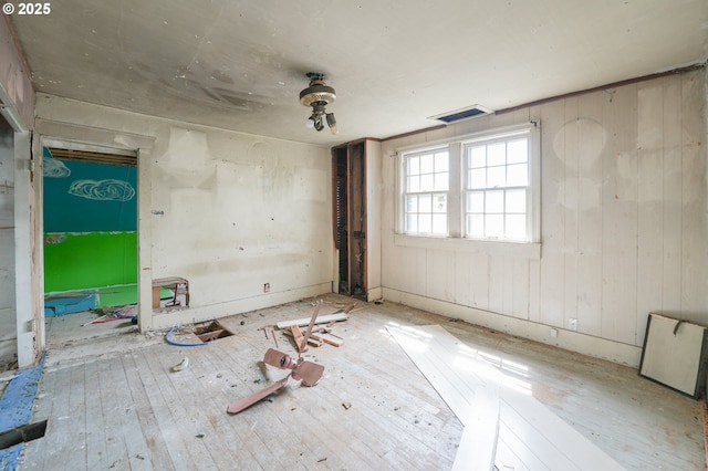 spare room featuring wood-type flooring and visible vents