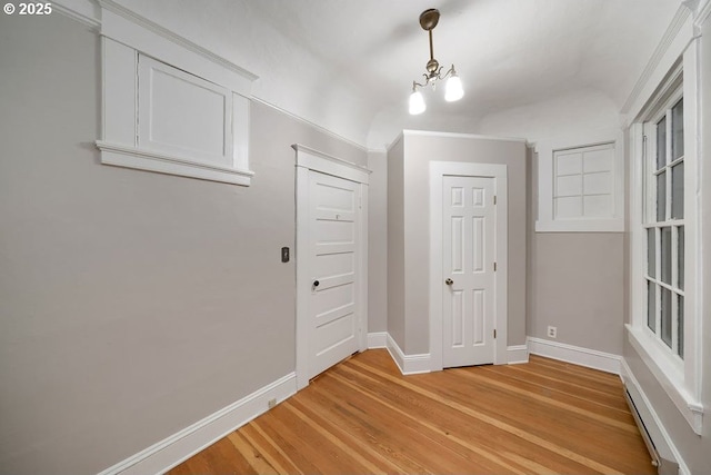 hallway featuring light hardwood / wood-style flooring and an inviting chandelier