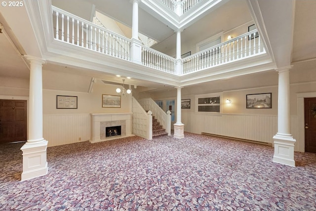 unfurnished living room featuring carpet floors, a high ceiling, and a baseboard heating unit