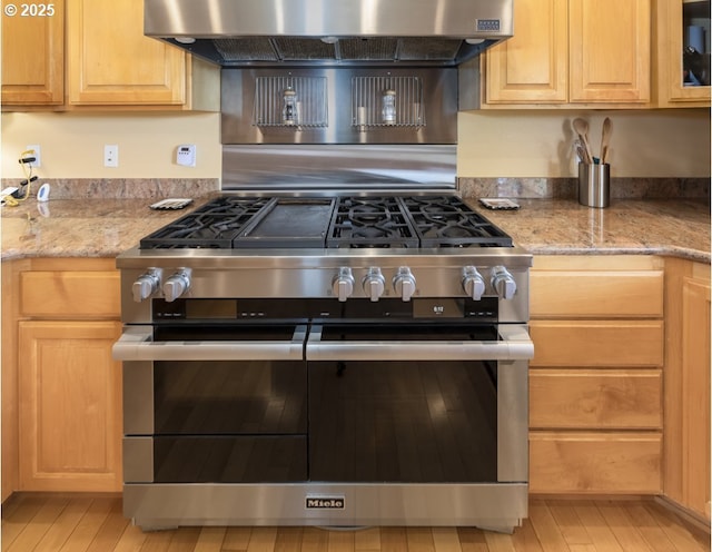 2567 SE Coriander, Grants Pass, OR 97527 - kitchen featuring double oven range, under cabinet range hood, light wood-style flooring, light stone countertops, and light brown cabinetry