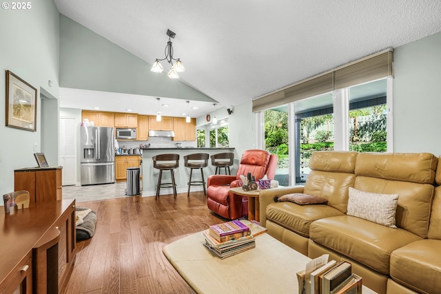 10145 SW Paulina Dr, Tualatin, OR 97062 - living area featuring a chandelier, wood finished floors, and vaulted ceiling