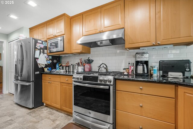 10145 SW Paulina Dr, Tualatin, OR 97062 - kitchen with dark stone counters, under cabinet range hood, decorative backsplash, and stainless steel appliances