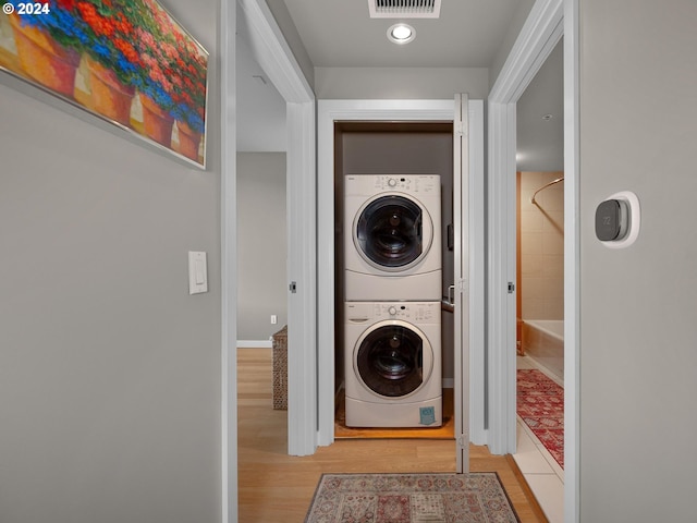 washroom with light wood-type flooring and stacked washer and dryer