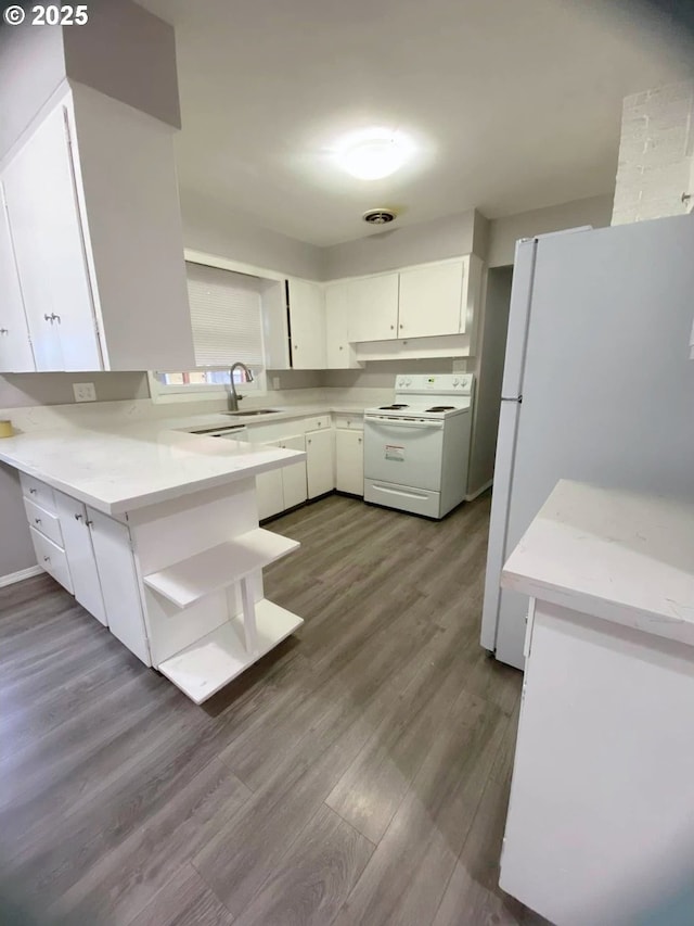 kitchen featuring white appliances, sink, light hardwood / wood-style floors, kitchen peninsula, and white cabinets