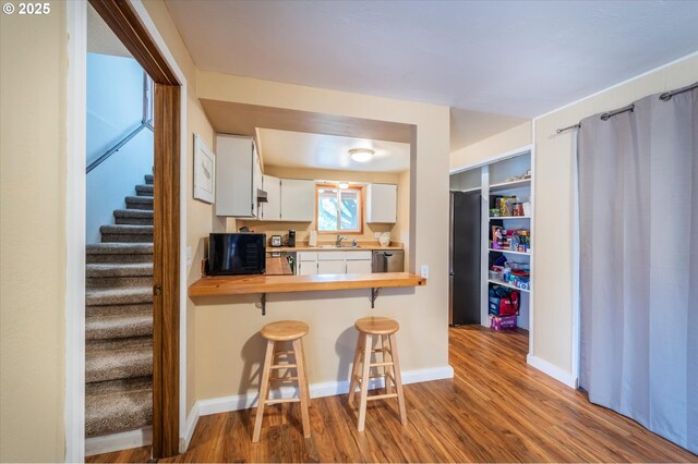 1145 Newport Ave SW, Bandon, OR 97411 - kitchen featuring butcher block counters, wood finished floors, appliances with stainless steel finishes, and a breakfast bar