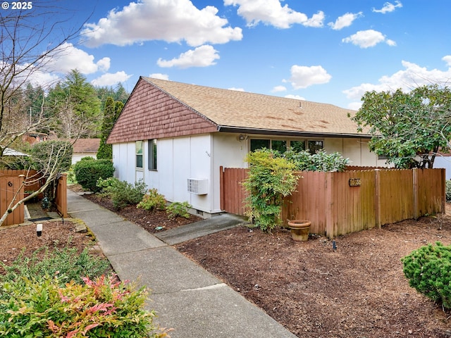 view of side of property featuring a shingled roof, fence, and board and batten siding