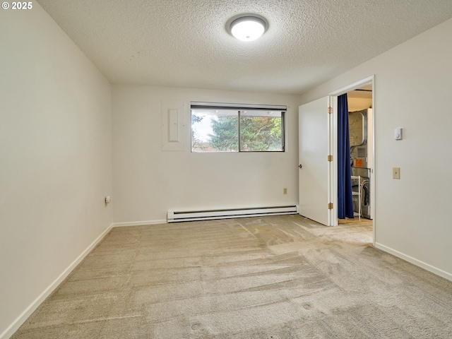 carpeted spare room with baseboards, a baseboard heating unit, and a textured ceiling