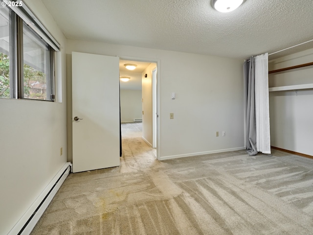 unfurnished bedroom with baseboards, a baseboard radiator, carpet, a textured ceiling, and a closet