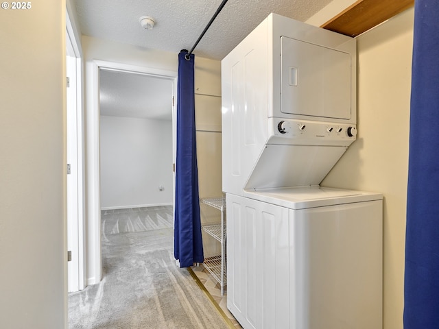 laundry area featuring stacked washer and clothes dryer, light colored carpet, a textured ceiling, laundry area, and baseboards