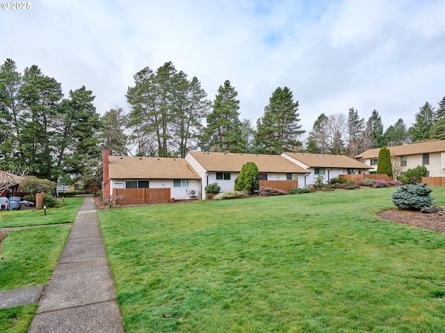 ranch-style house featuring fence and a front lawn