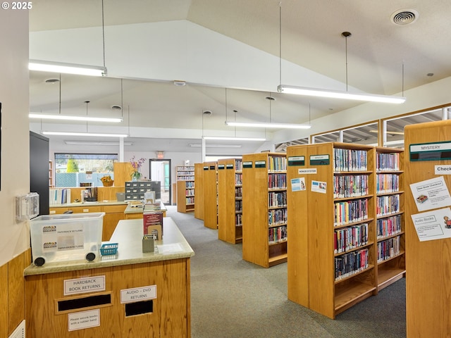 interior space with high vaulted ceiling, carpet flooring, wood walls, and visible vents