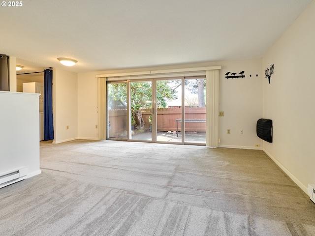 unfurnished living room with baseboards, a baseboard heating unit, and carpet flooring