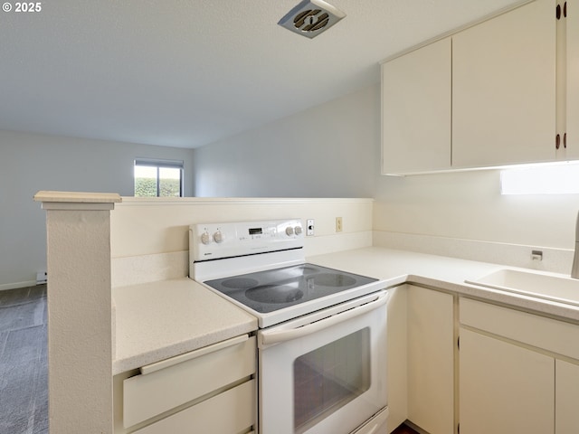 kitchen with a sink, light countertops, and white electric range