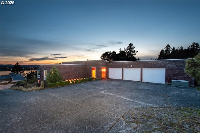 garage at dusk with aphalt driveway