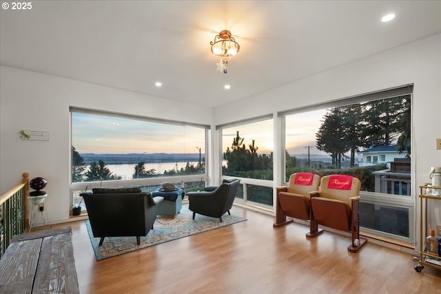 living room with recessed lighting, a water view, and wood finished floors