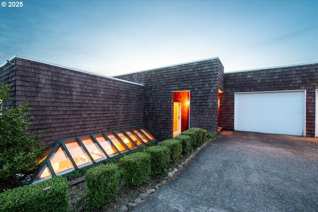 view of front of property featuring aphalt driveway and an attached garage