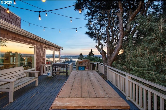 deck at dusk with outdoor dining space