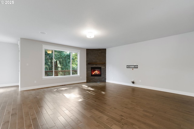 unfurnished living room featuring a large fireplace and dark wood-type flooring