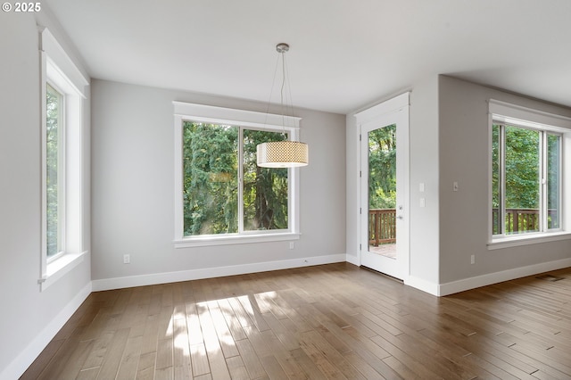 unfurnished dining area featuring hardwood / wood-style flooring and a healthy amount of sunlight