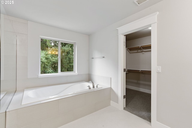 bathroom with a relaxing tiled tub