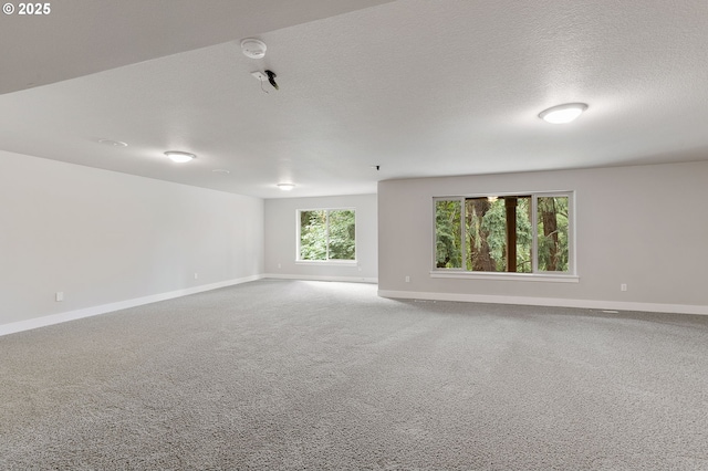 carpeted empty room with a textured ceiling