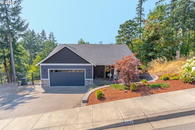 view of front of home with an attached garage, fence, stone siding, and driveway