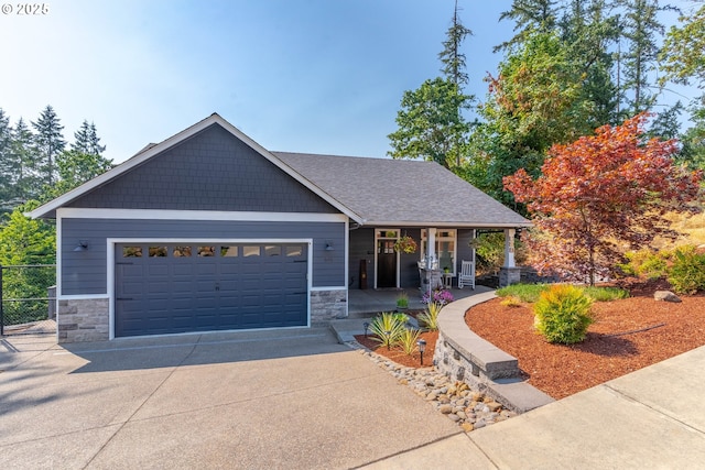 craftsman house featuring a garage, stone siding, a porch, and driveway