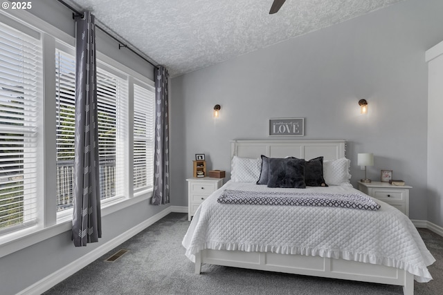 carpeted bedroom with visible vents, ceiling fan, a textured ceiling, and baseboards