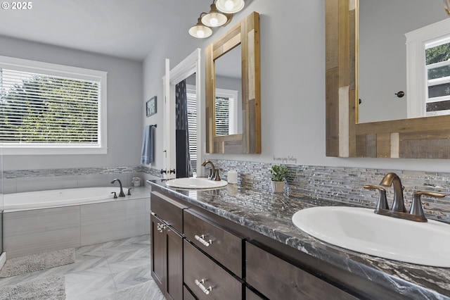 bathroom featuring a sink, a healthy amount of sunlight, and a bath