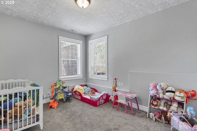 carpeted bedroom with visible vents, a textured ceiling, and baseboards