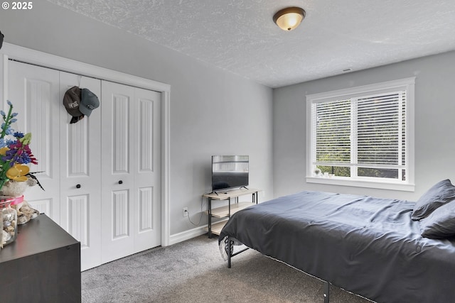 bedroom with baseboards, carpet, a closet, and a textured ceiling