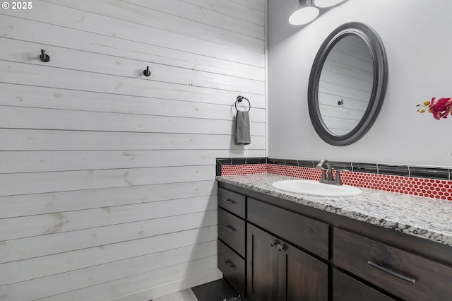 bathroom featuring wood walls and vanity