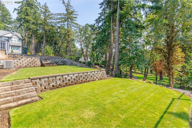 view of yard with central AC unit and fence