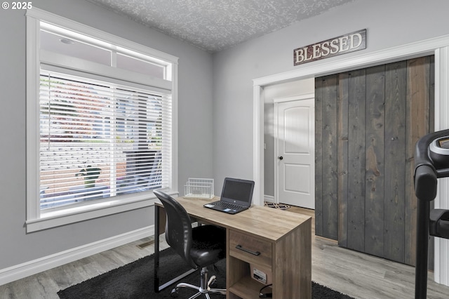 office space featuring baseboards, a textured ceiling, and wood finished floors