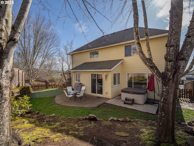 back of property featuring a patio, a fenced backyard, and a hot tub