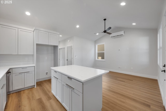 kitchen featuring white cabinets, a kitchen island, a wall unit AC, and light hardwood / wood-style flooring