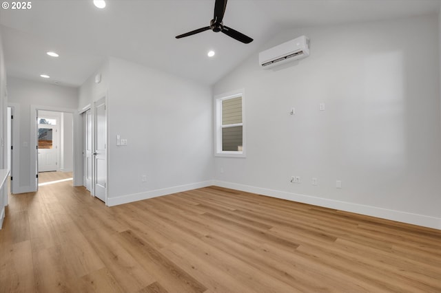 unfurnished room featuring vaulted ceiling, an AC wall unit, ceiling fan, and light wood-type flooring