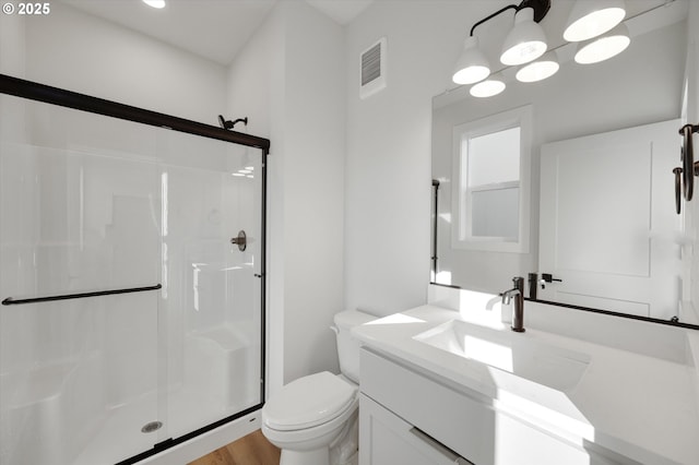 bathroom featuring an enclosed shower, vanity, and toilet