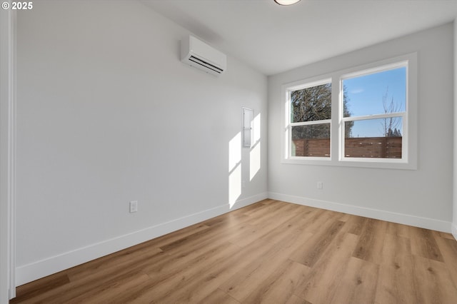 unfurnished room with a wall mounted air conditioner and light hardwood / wood-style floors