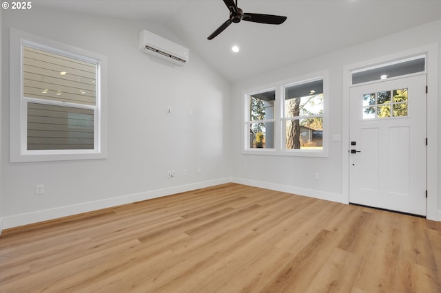 foyer entrance with a wall mounted air conditioner, light hardwood / wood-style flooring, ceiling fan, and vaulted ceiling