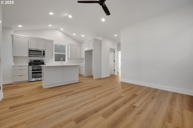 kitchen featuring white cabinetry, appliances with stainless steel finishes, a center island, and light hardwood / wood-style floors