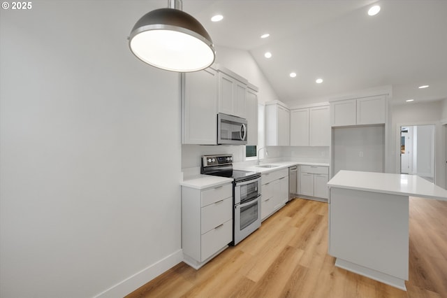 kitchen featuring white cabinetry, sink, stainless steel appliances, and a kitchen island