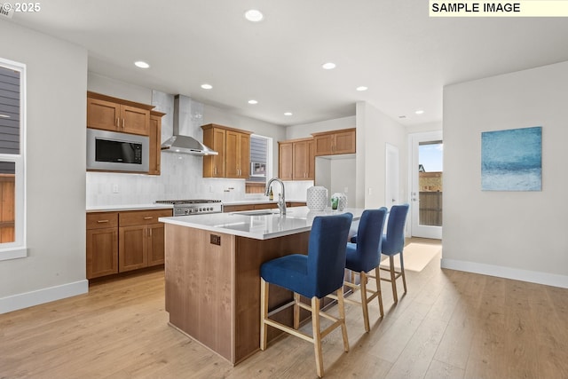 8276 SE Orion Ln, Hillsboro, OR 97123 - kitchen featuring wall chimney exhaust hood, stainless steel microwave, a sink, brown cabinets, and recessed lighting